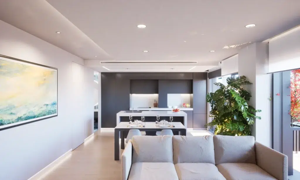 Living Spaces in Spain often feature enclosed kitchens, unlike Northern Europe, where open-plan designs are more common. This modern kitchen with a central island showcases a sleek and functional layout.