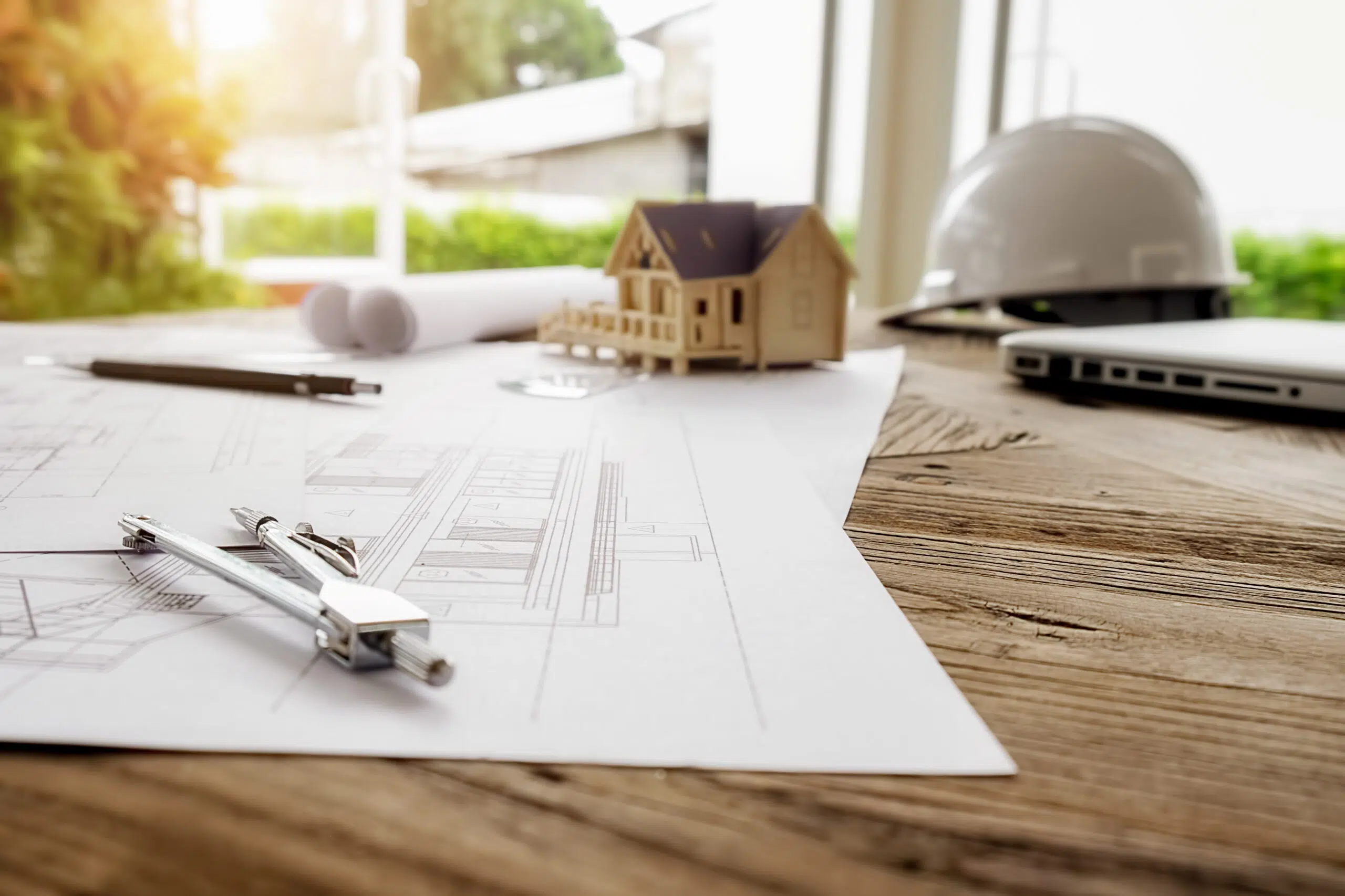 Spanish Building Code (CTE): A Practical Guide for Foreigners in Spain 2 Work desk with architectural plans, tools, and a house model, representing the construction process according to the Spanish Building Code.