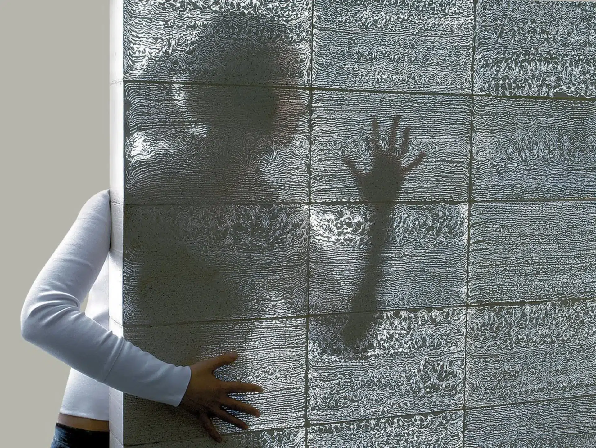 Wall made of Litracon translucent concrete showing human silhouette — an example of new materials in residential architecture.