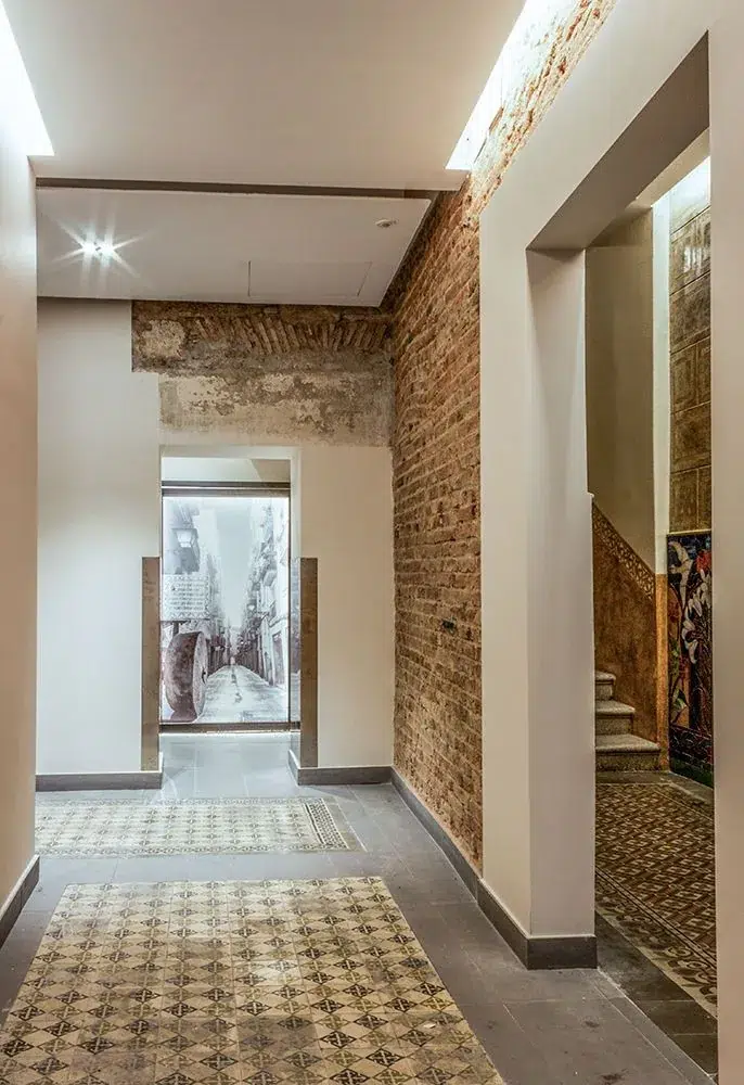 Corridor with exposed brick and restored encaustic tiles, a case to renovate or build from scratch.
