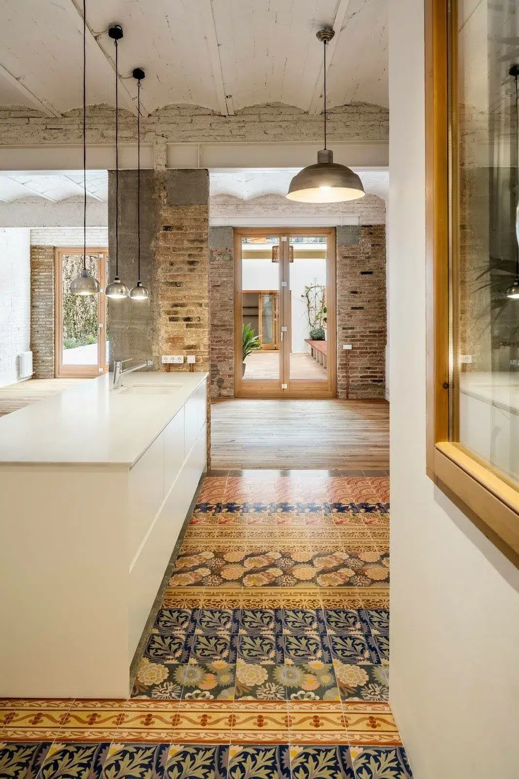 Open kitchen with industrial pendants and patterned encaustic floor—ideas to renovate or build from scratch.